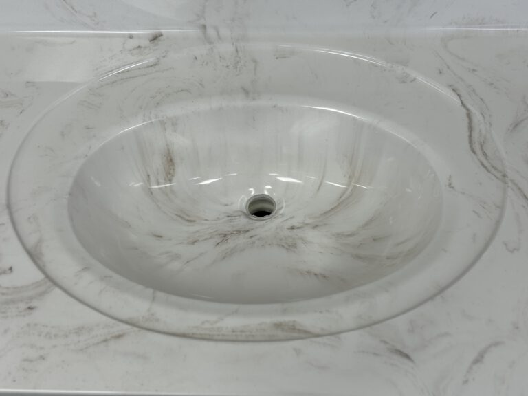 oval cast marble sink integrated into cast marble countertop with an inset